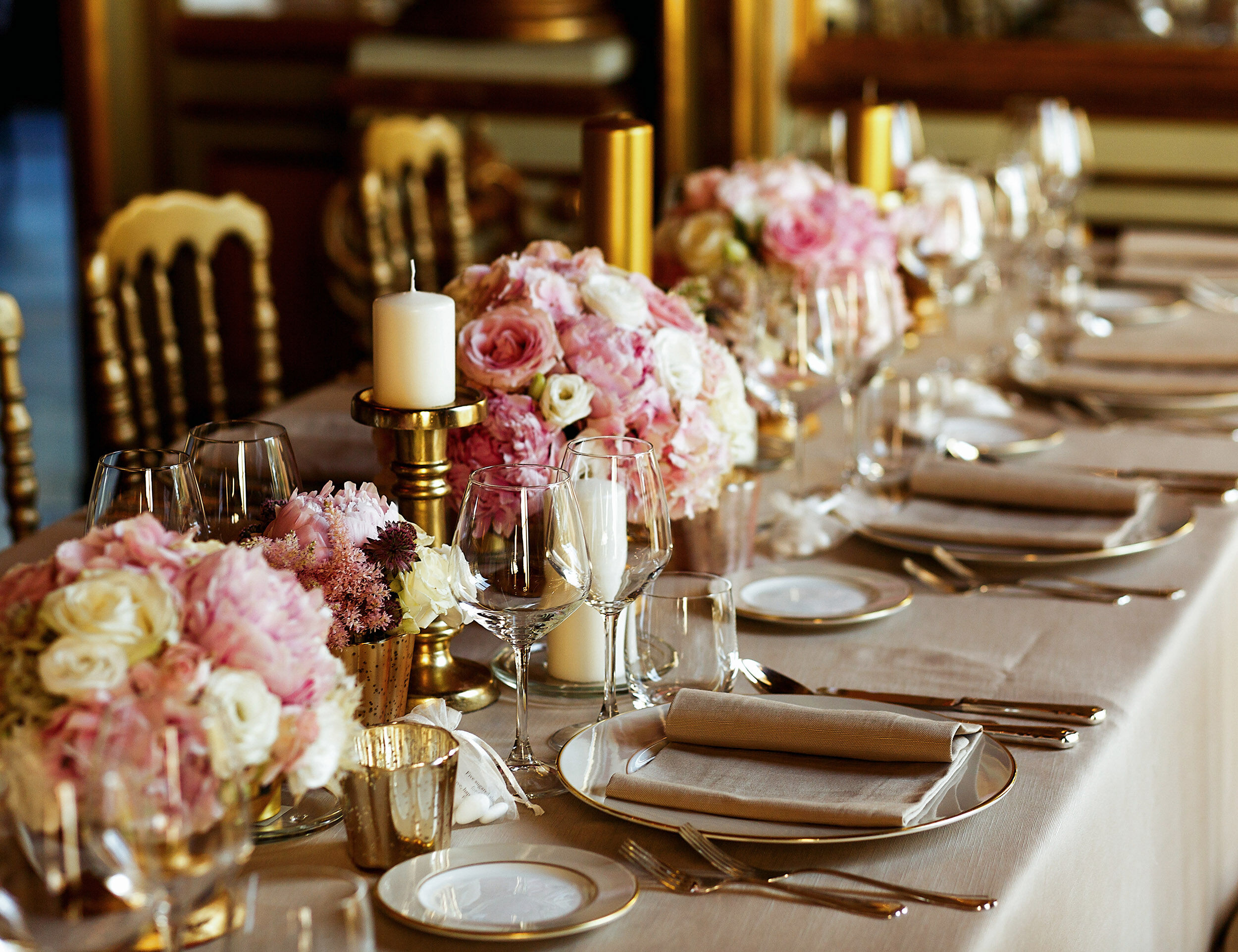 Wedding table beautifully decorated using candles, flowers, and crockery.